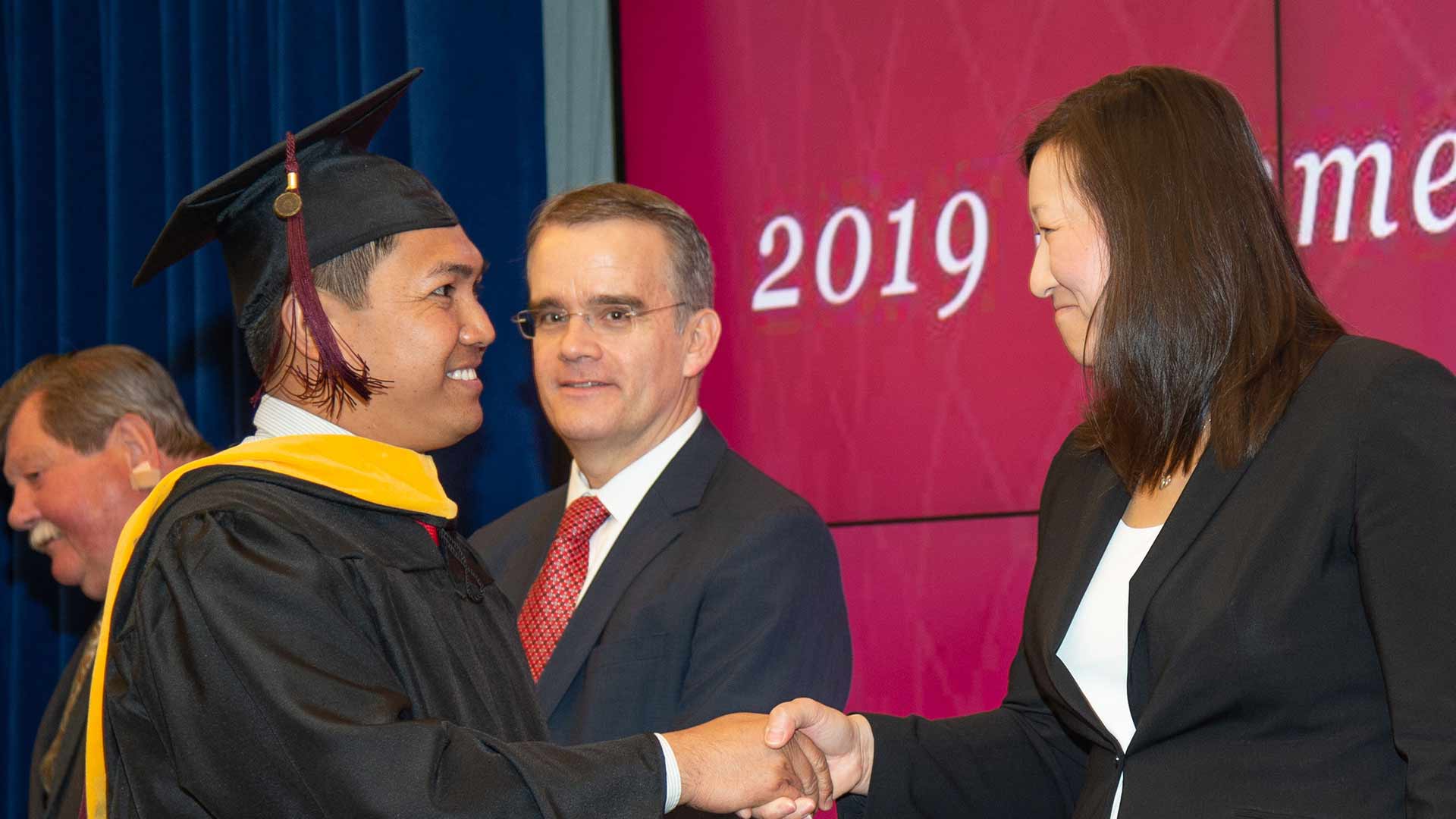DSS student Las Bryner receives congratulations from the Deputy Under Secretary of Defense for Intelligence, Kari Bingen, at the 2019 department commencement ceremony.