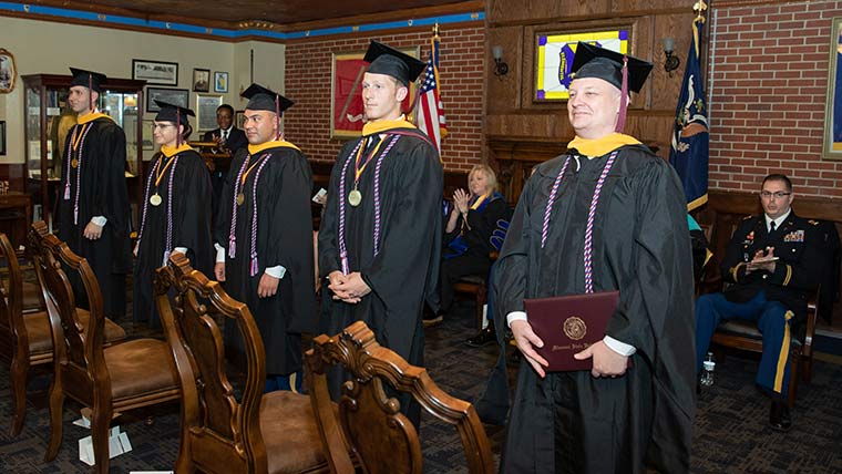 Defense and strategic studies students in cap and gown at 2019 commencement ceremony.