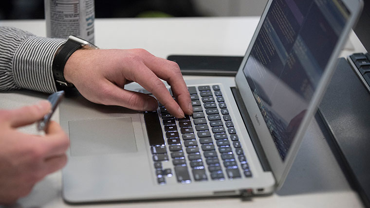 A student unplugging a thumbdrive from a laptop.