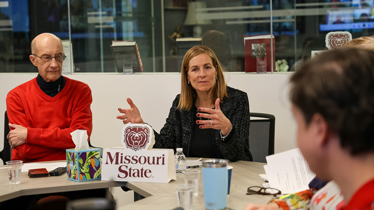 Students seated around table with faculty