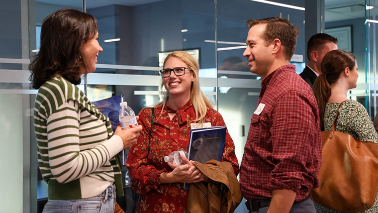 Three people smiling at social networking event