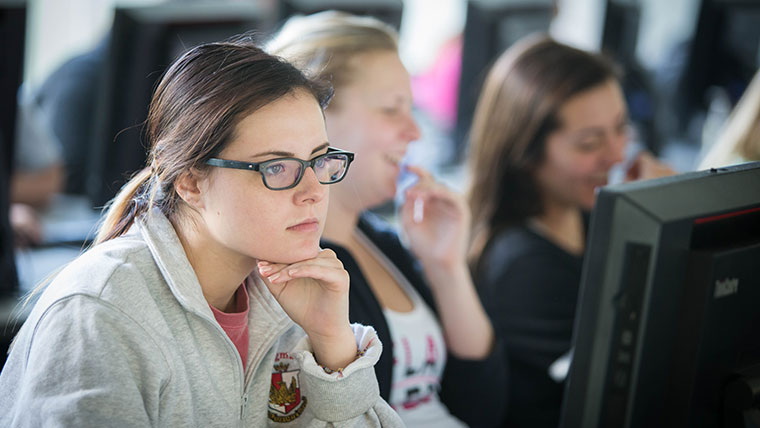 A student focuses on her computer monitor.