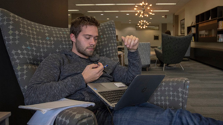 Student studying on laptop.